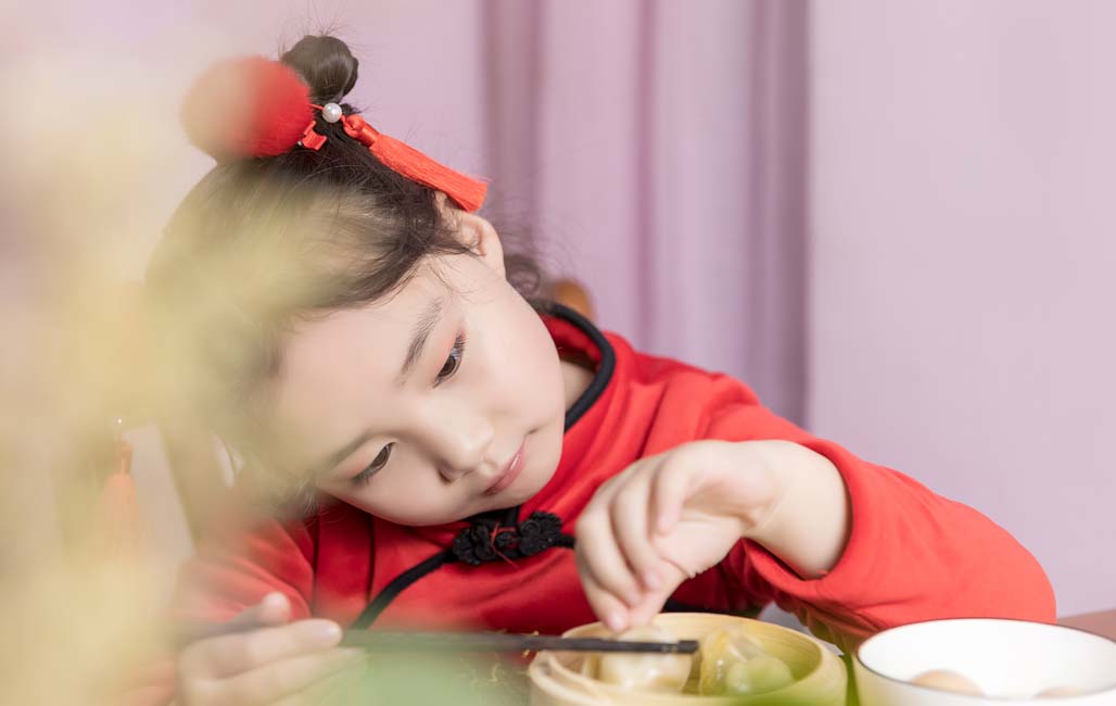Cô gái Trung Quốc ăn bánh bao trong bộ quần áo năm mới