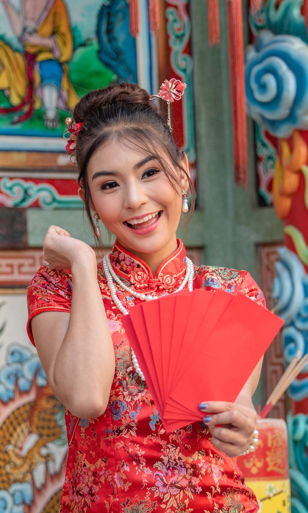 Cô gái châu Á xinh đẹp mặc váy đỏ cầm phong bì đỏ