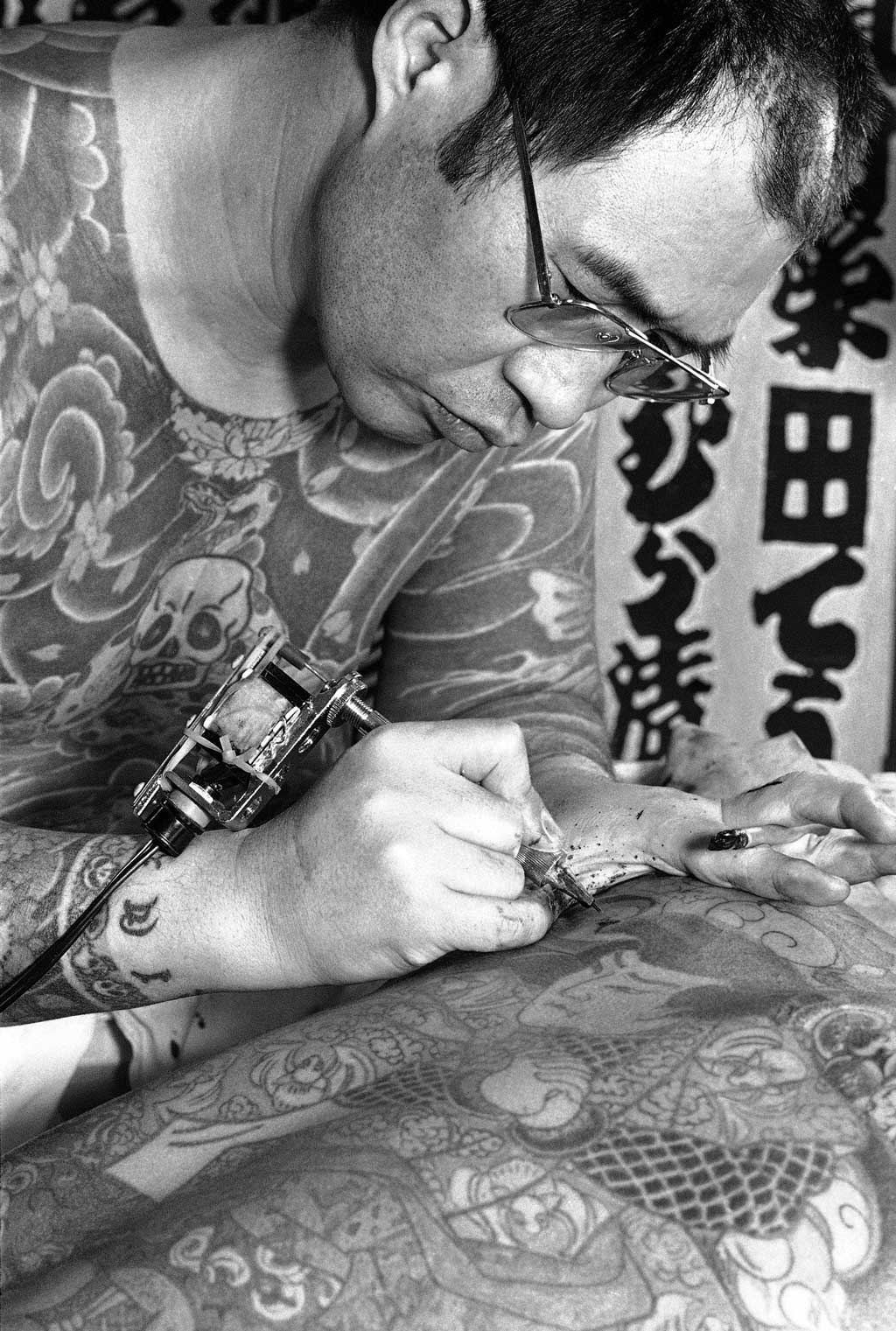 Nghệ sĩ xăm hình Nhật Bản sử dụng máy xăm điện để nhúng sắc tố vào da của khách hàng