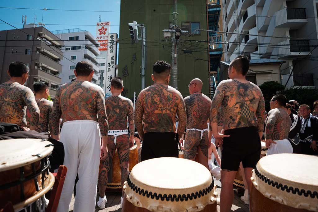 Những người đàn ông với hình xăm truyền thống của Nhật Bản tạo dáng chụp ảnh trên đường về phía đền Asakusa