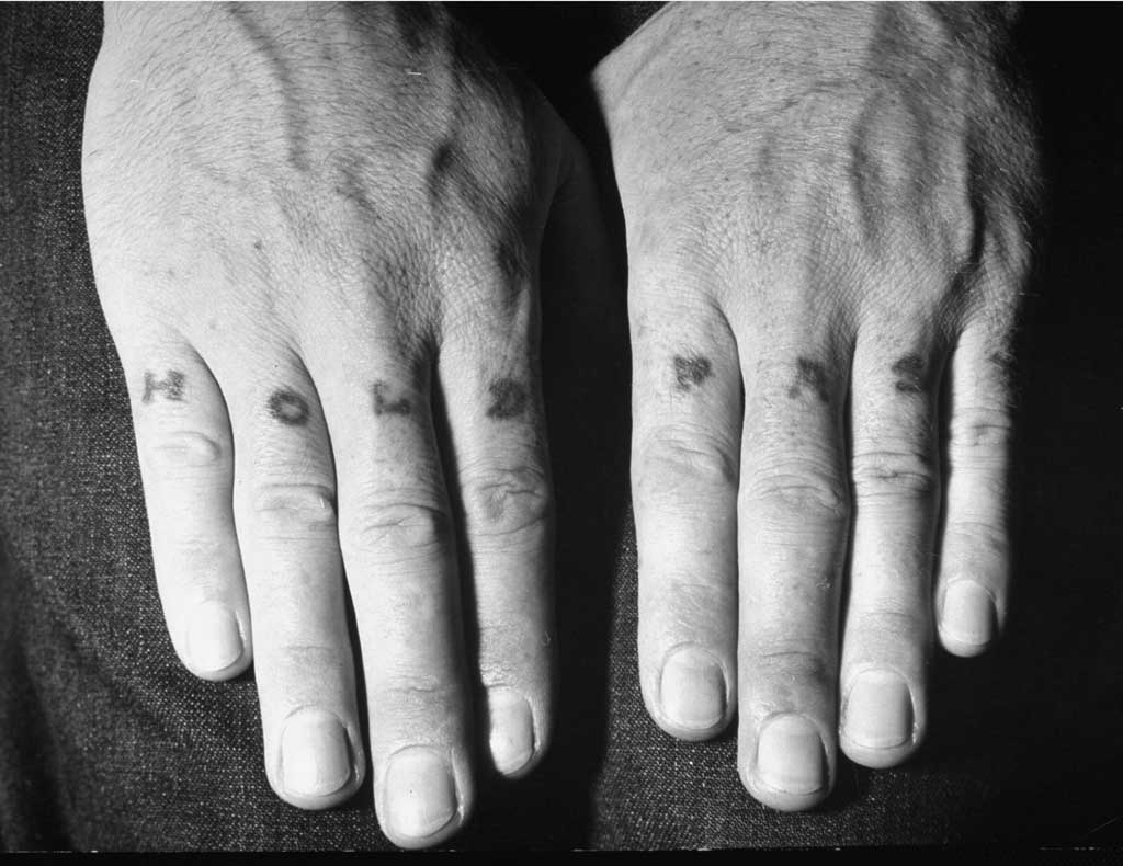 Bàn tay của một người đàn ông cho thấy hình xăm trên đốt ngón tay của mình