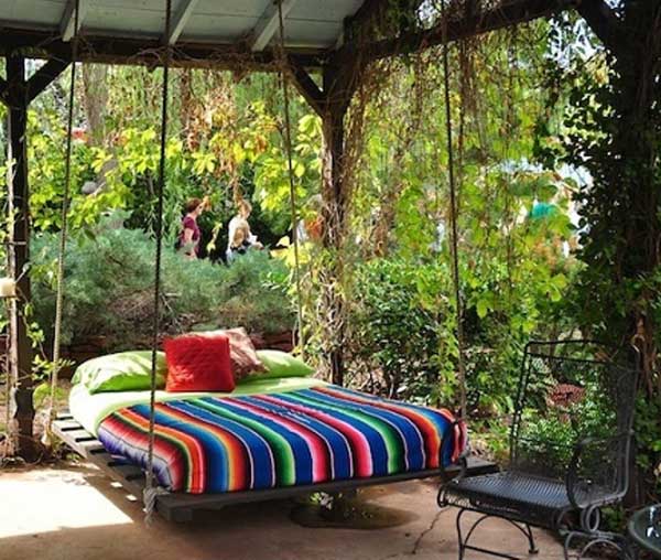Giường treo với chăn, gối nhiều màu sắc cực kỳ lý tưởng để đặt ngoài vườn nhà.