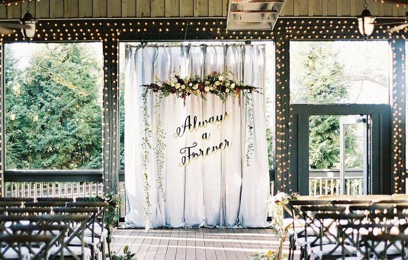 Bạn có thể nhờ đơn vị tổ chức tiệc cưới cho dựng những bức tường tạo hình màu trắng hoặc dùng rèm treo đính từ các loại lá tự nhiên để giúp khu vực sân khấu thêm bắt mắt