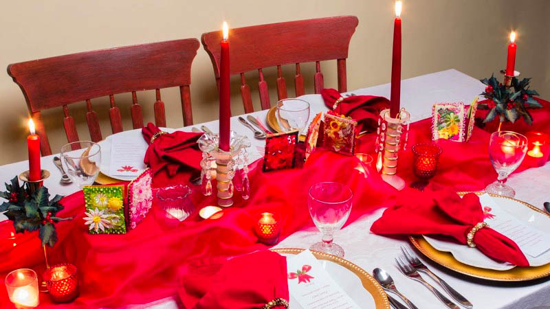 Trang trí bàn tiệc Noel với nến và hoa màu đỏ